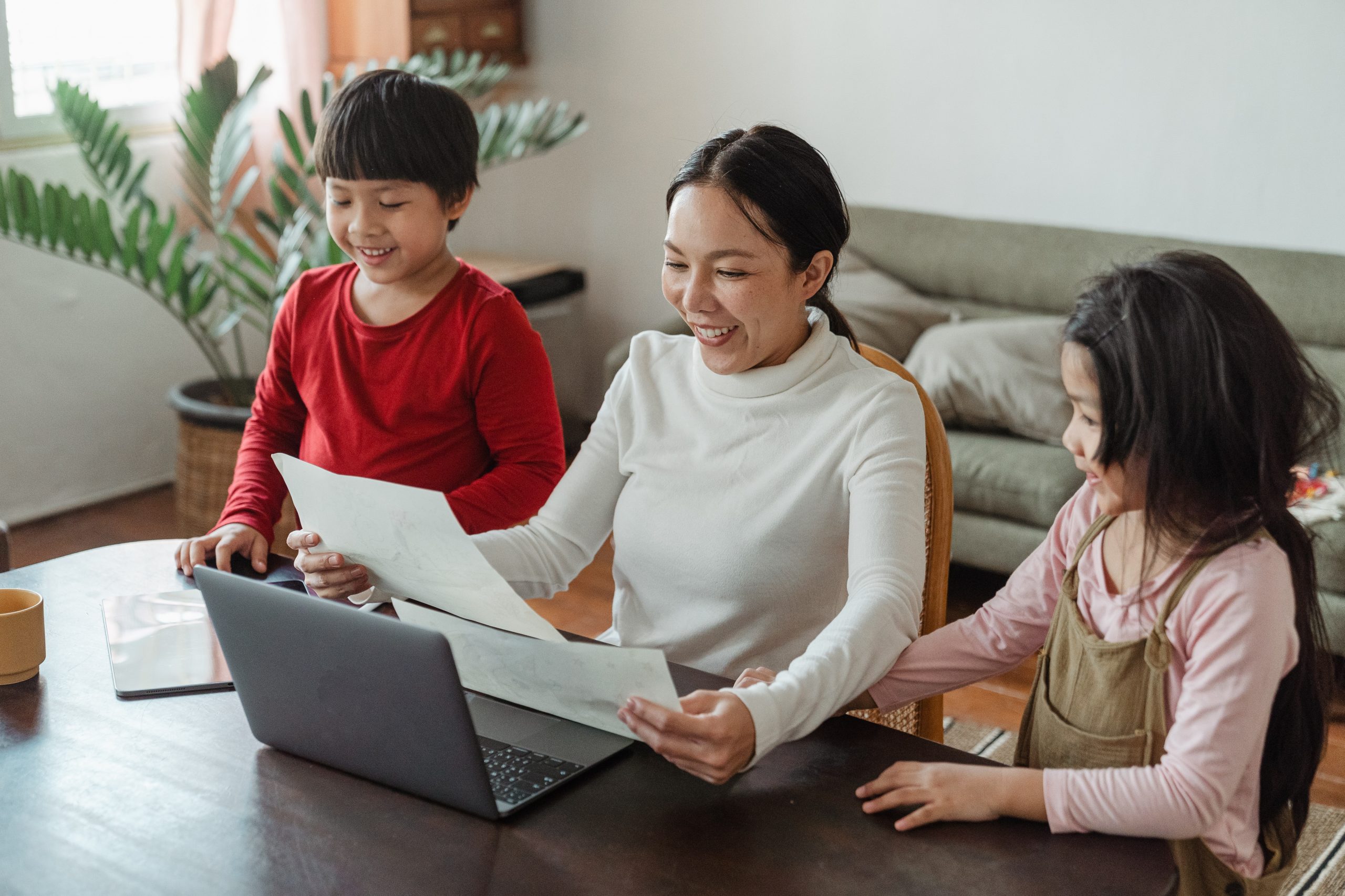 A chinese mother looking at marks sheet along her kids