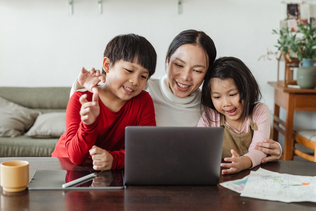 A chinese mother with her kids viewing laptop